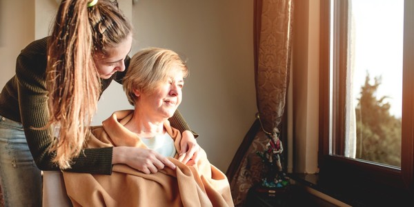 Een jonge vrouw legt een deken over een andere vrouw
